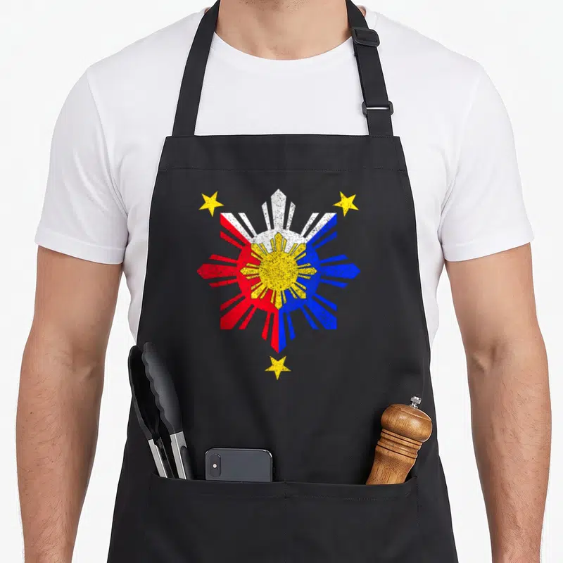 Pinoy filipino apron - Distressed yellow sun with red white blue rays and three yellow stars — shown on a black cotton canvas apron against a white background