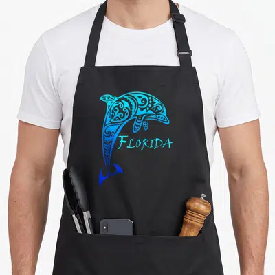Dolphin florida apron - Blue gradient tribal dolphin with FLORIDA script in line art style — shown on a black cotton canvas apron against a white background