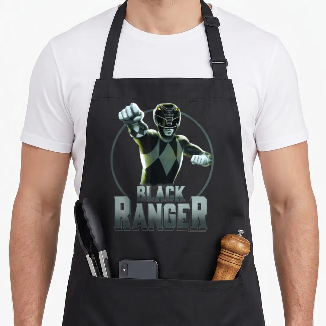 Portrait karate apron - Realistic Black Ranger in fighting pose inside grey circle with stacked text — shown on a black cotton canvas apron against a white background