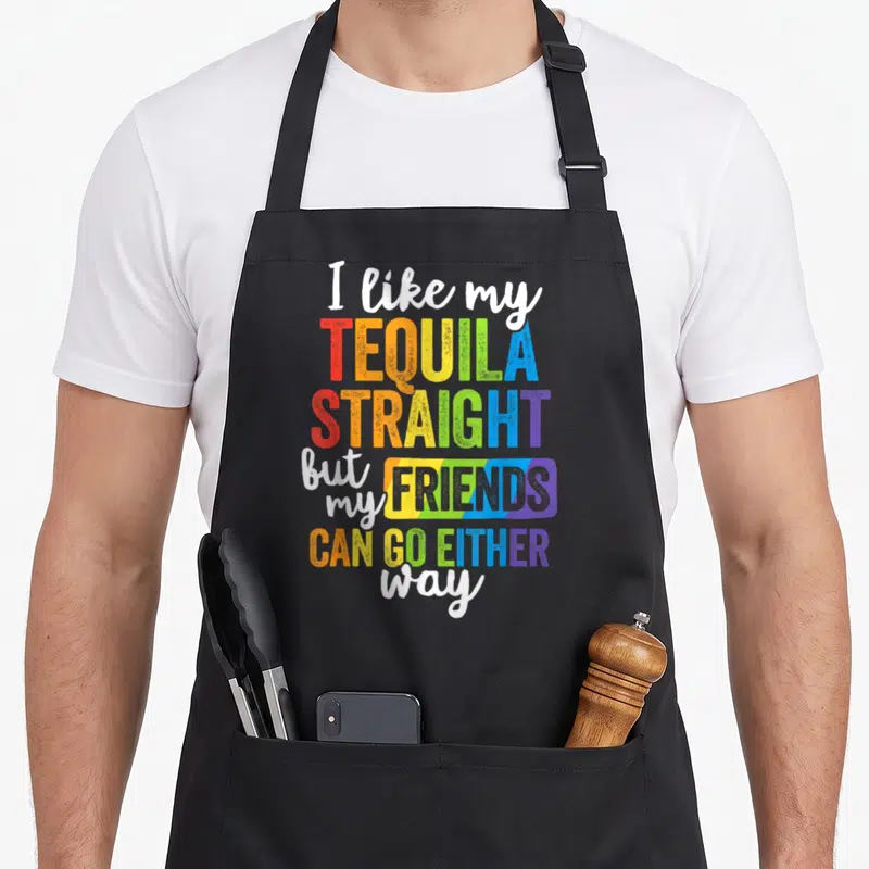 Lgbt friends apron - Rainbow typography reading I like my TEQUILA STRAIGHT but my FRIENDS CAN GO EITHER way — shown on a black cotton canvas apron against a white background
