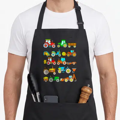 Toddler farm apron - Ten cartoon tractors in red, green, blue, orange, and yellow arranged in five rows of two — shown on a black cotton canvas apron against a white background