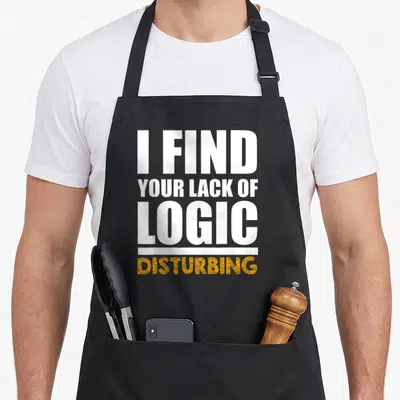 Lack logic find aprons - Stacked white and yellow text reading I Find Your Lack of Logic Disturbing — shown on a black cotton canvas apron against a white background