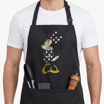 Simple friends apron - Distressed cartoon Minnie Mouse in polka dot dress and yellow shoes — shown on a black cotton canvas apron against a white background