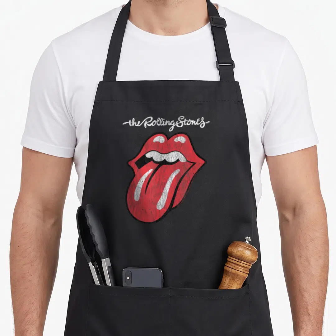 Script rolling stones apron - Distressed red mouth with tongue and white script text on grey background — shown on a black cotton canvas apron against a white background