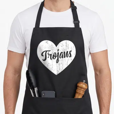 Trojan sport girl apron - Distressed white heart with grey Trojans script text centered on front panel — shown on a black cotton canvas apron against a white background