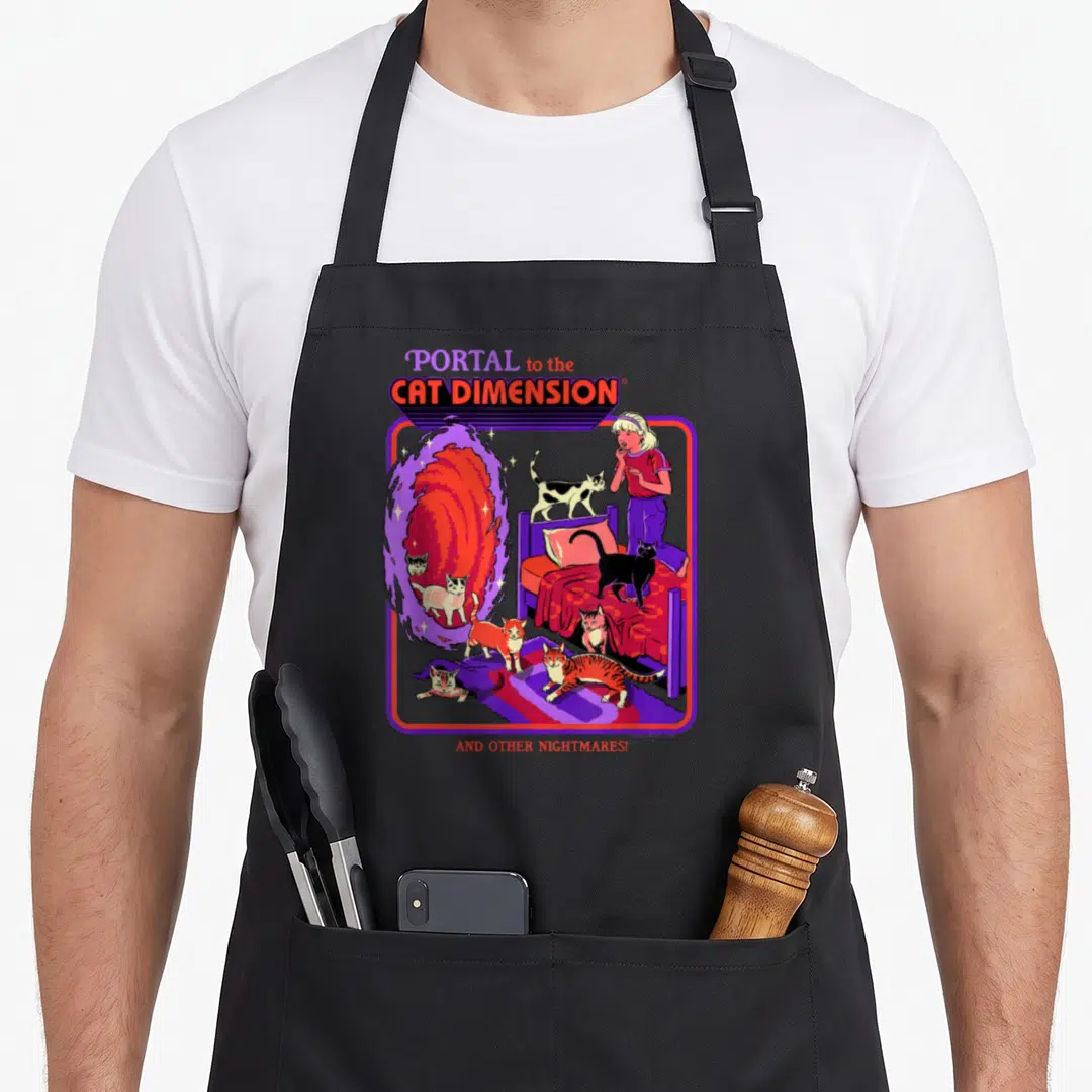 Steven cat apron - Cartoon woman and cats near swirling portal with purple border and red text — shown on a black cotton canvas apron against a white background