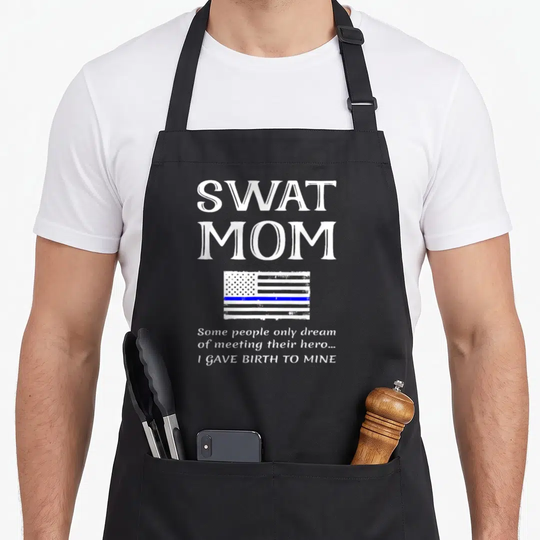 Swat mother's apron - SWAT MOM text, distressed flag with blue line, and birth quote — shown on a black cotton canvas apron against a white background