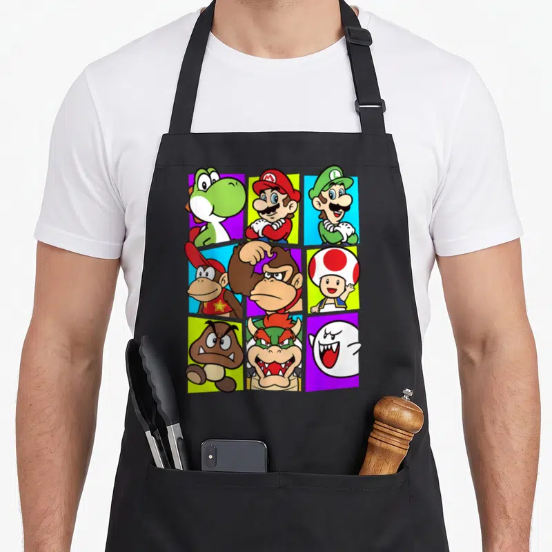 Gang box apron - Nine cartoon character portraits in a 3x3 grid on red, green, blue, purple, and yellow rectangular — shown on a black cotton canvas apron against a white background