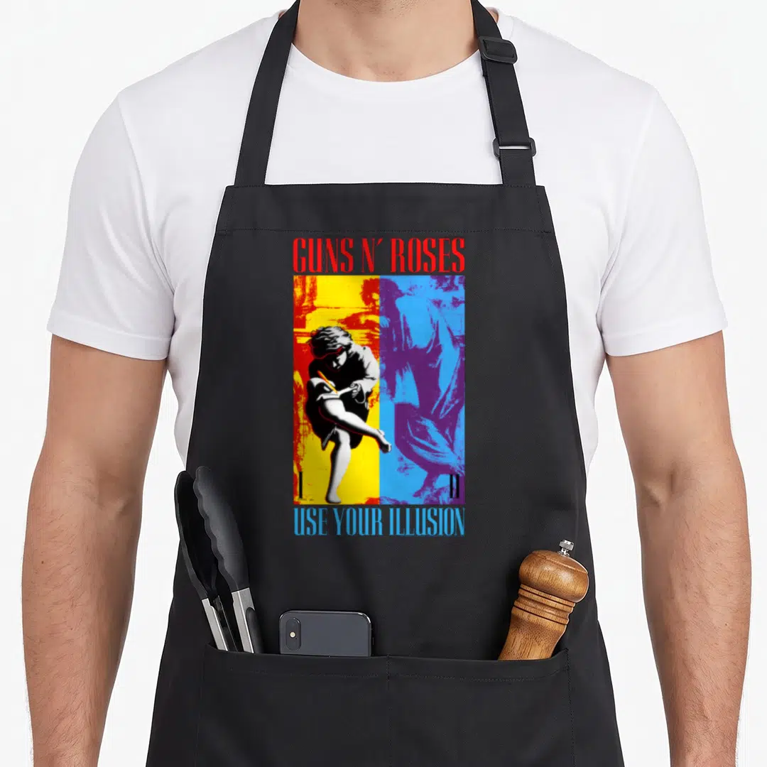 Gun split apron - Guns N Roses Use Your Illusion two figures split yellow blue background red blue text — shown on a black cotton canvas apron against a white background