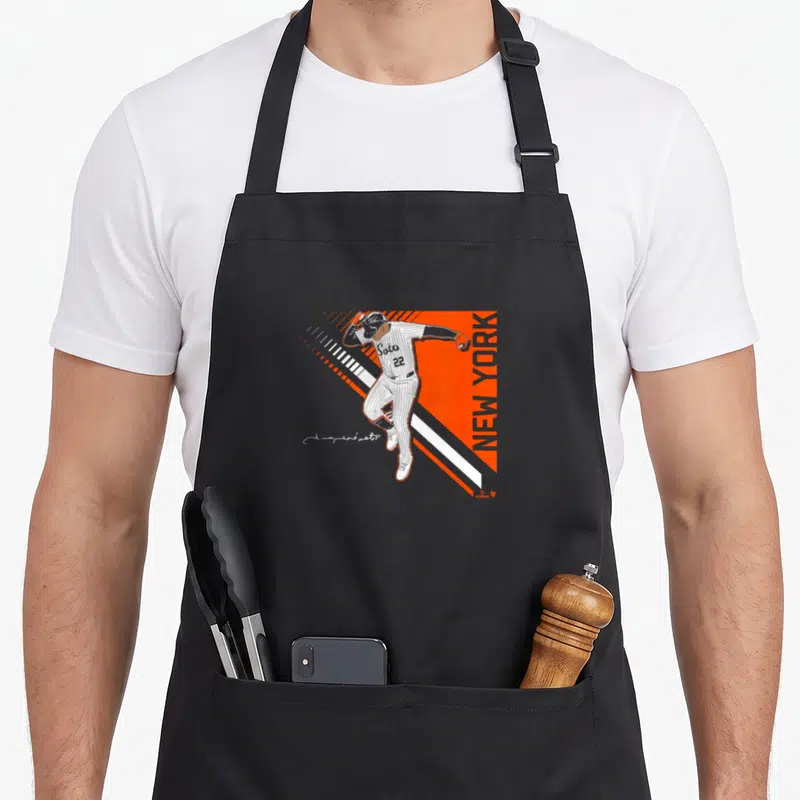 Soto new york aprons - Minimalist baseball player on orange background with white diagonal stripes and vertical NEW — shown on a black cotton canvas apron against a white background