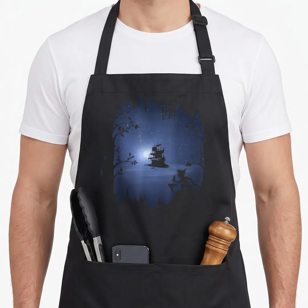 Peter good friday apron - Minimalist ship and figure silhouette in blue and white moonlit scene framed by leaves — shown on a black cotton canvas apron against a white background
