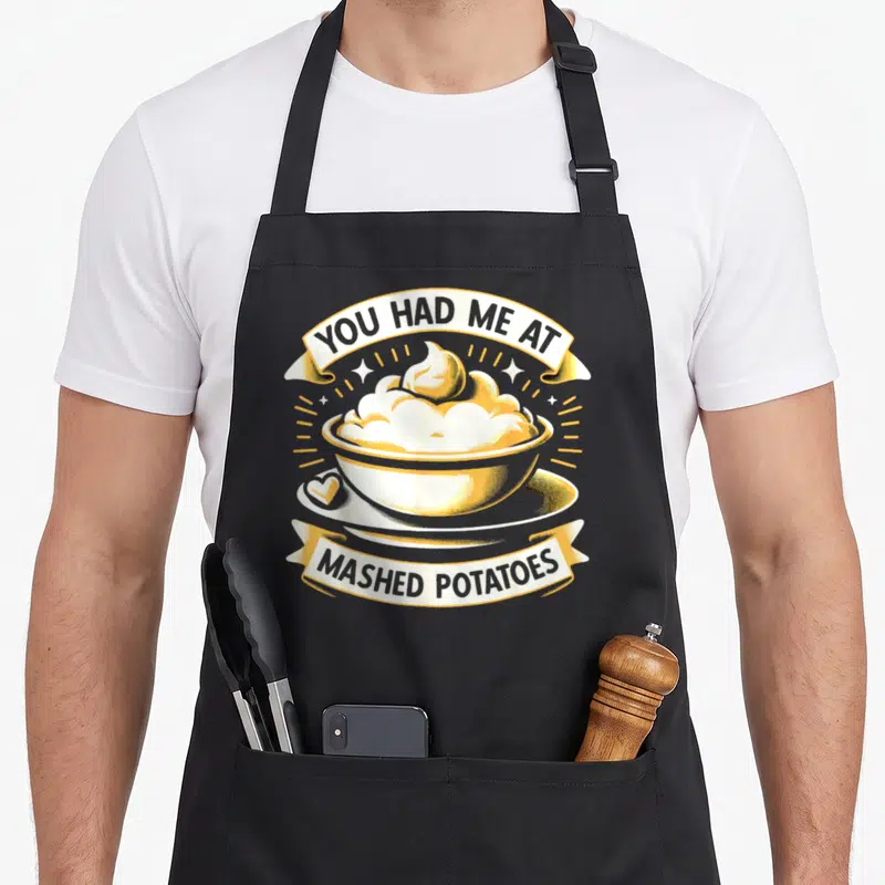 Vintage mashed thanksgiving apron - Retro yellow and white bowl of mashed potatoes with ribbon text reading You Had Me — shown on a black cotton canvas apron against a white background