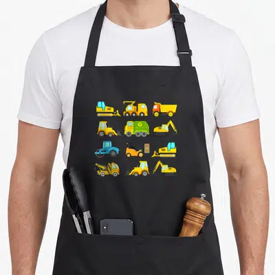 Sleeved truck apron - Twelve cartoon construction vehicles in yellow, blue, and green grid layout — shown on a black cotton canvas apron against a white background