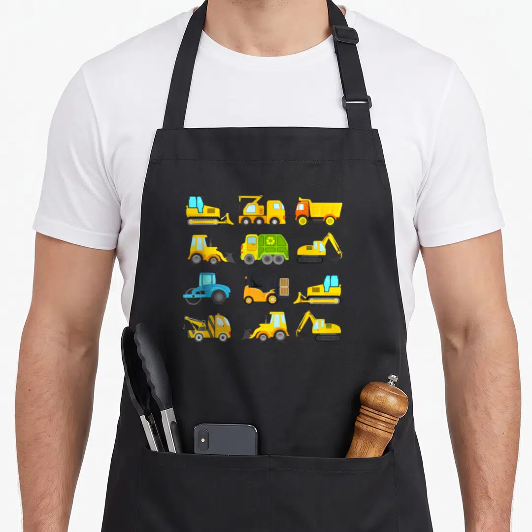 Sleeved truck apron - Twelve cartoon construction vehicles in yellow, blue, and green grid layout — shown on a black cotton canvas apron against a white background