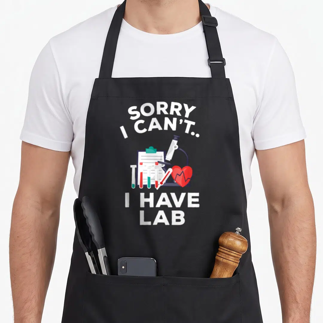 Pre student aprons - Sorry I Can't I Have Lab text with cartoon microscope and test tubes — shown on a black cotton canvas apron against a white background