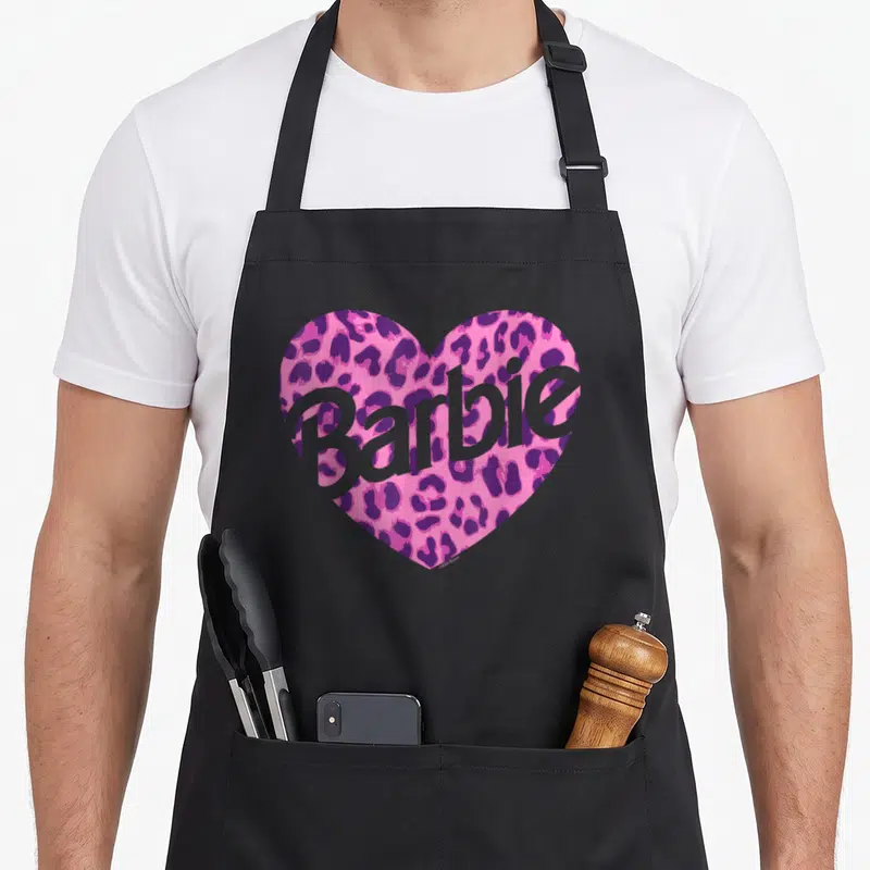 Funny leopard apron - Pink leopard heart with grey Barbie text overlay — shown on a black cotton canvas apron against a white background