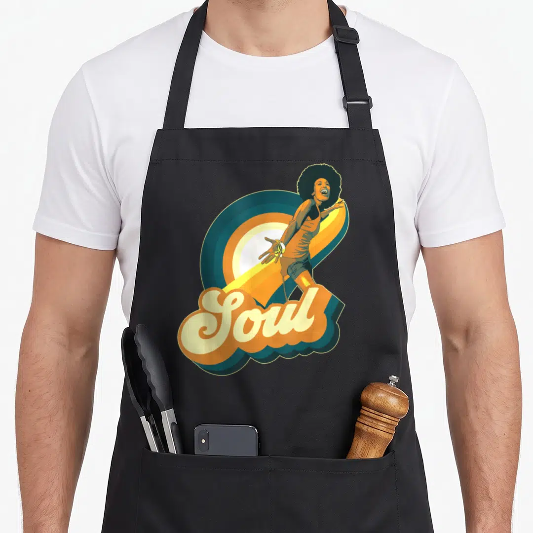 Funk afro 70s apron - Retro woman with afro overlapping teal orange yellow brown curves above Soul script lettering — shown on a black cotton canvas apron against a white background