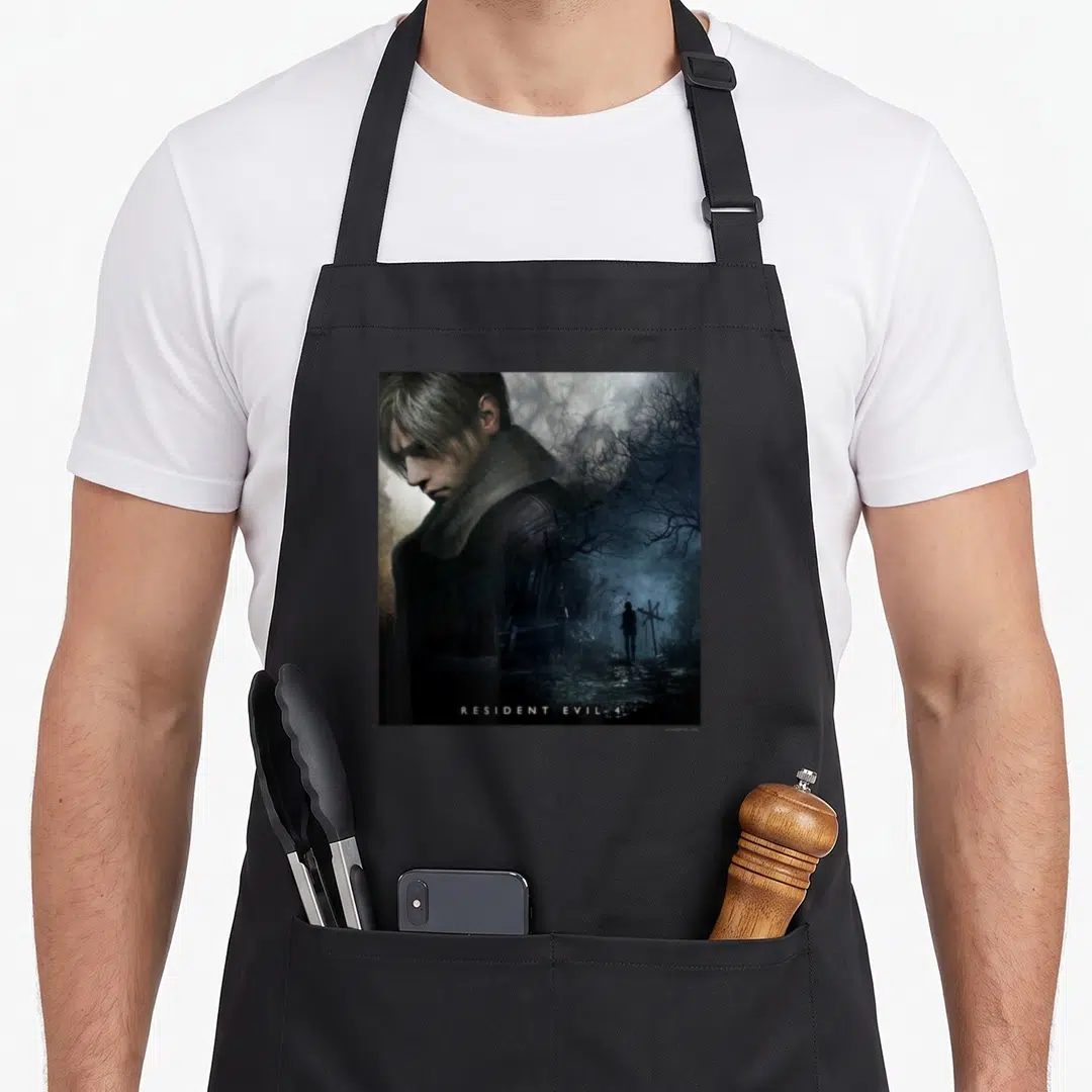 Capcom crew apron - Man's face blending into dark forest with RESIDENT EVIL 4 text at bottom — shown on a black cotton canvas apron against a white background