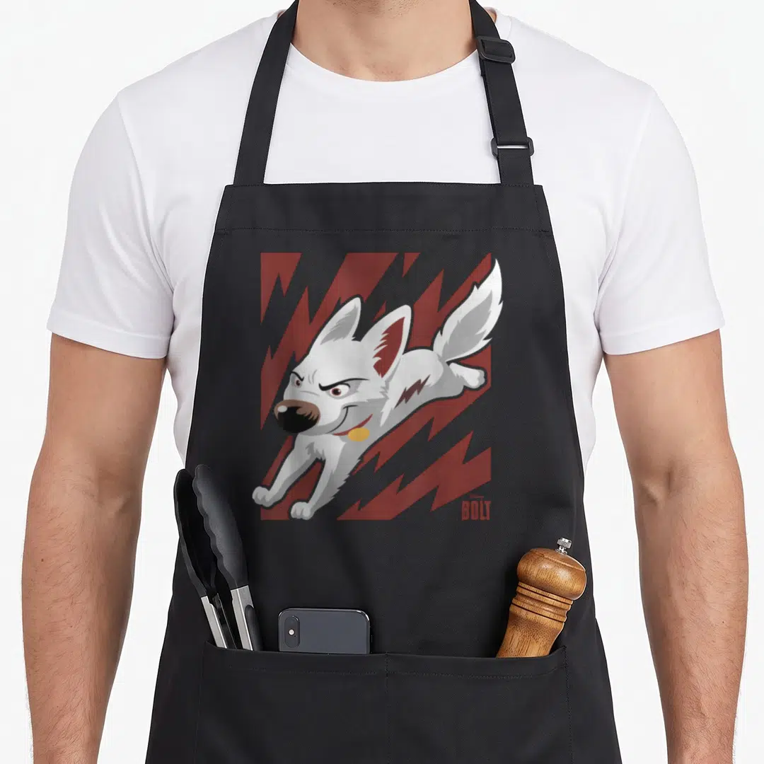 Bolt dog apron - White cartoon dog leaping on red lightning background with BOLT text below — shown on a black cotton canvas apron against a white background