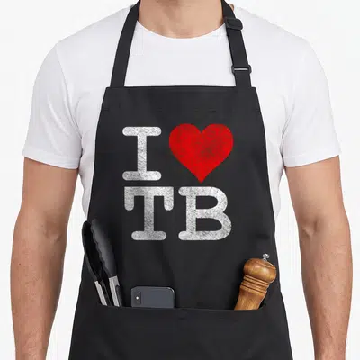 Tampa football apron - White I, red heart, and white TB letters arranged vertically — shown on a black cotton canvas apron against a white background