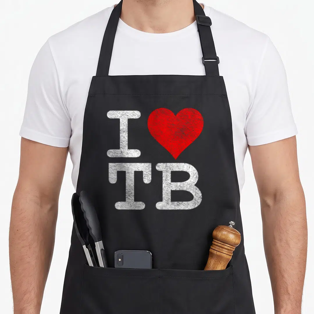 Tampa football apron - White I, red heart, and white TB letters arranged vertically — shown on a black cotton canvas apron against a white background