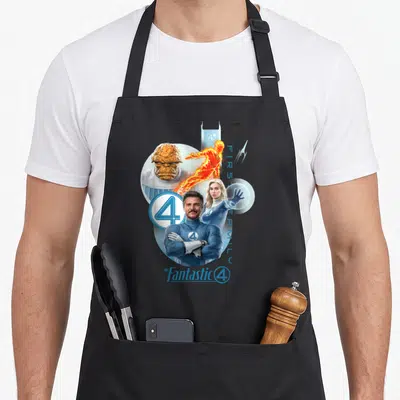 Fantastic family aprons - Photo-style Fantastic Four cluster with blue orange white suits, vertical FIRST FAMILY text — shown on a black cotton canvas apron against a white background