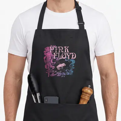 Nouveau animal apron - Pink Floyd text, white pig, pink figure, blue and purple swirls — shown on a black cotton canvas apron against a white background