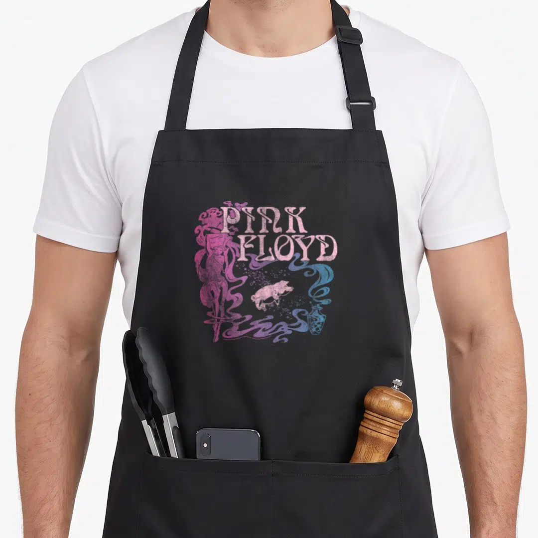 Nouveau animal apron - Pink Floyd text, white pig, pink figure, blue and purple swirls — shown on a black cotton canvas apron against a white background