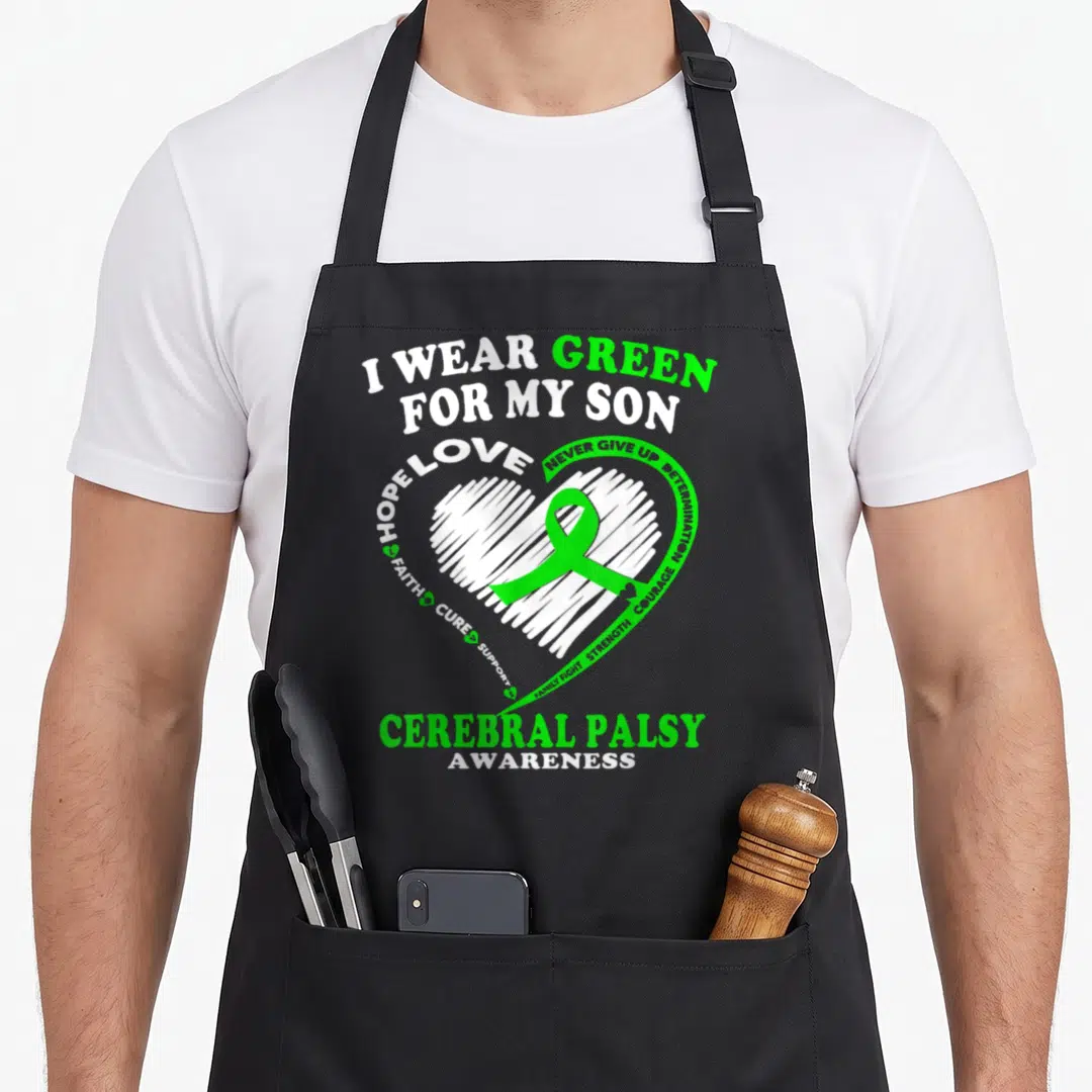 Cerebral dad and son aprons - I WEAR GREEN FOR MY SON text with green ribbon inside white scribbled heart — shown on a black cotton canvas apron against a white background