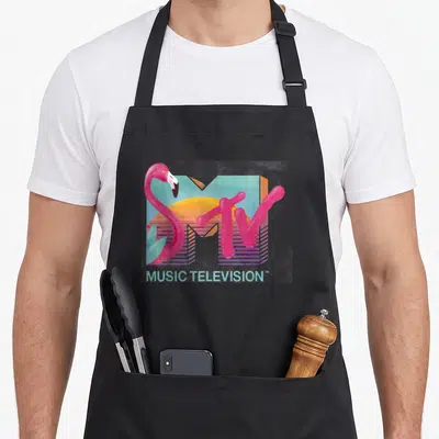 Distressed flamingo apron - Retro MTV logo with pink flamingo, sun, and MUSIC TELEVISION text in pastel colors — shown on a black cotton canvas apron against a white background