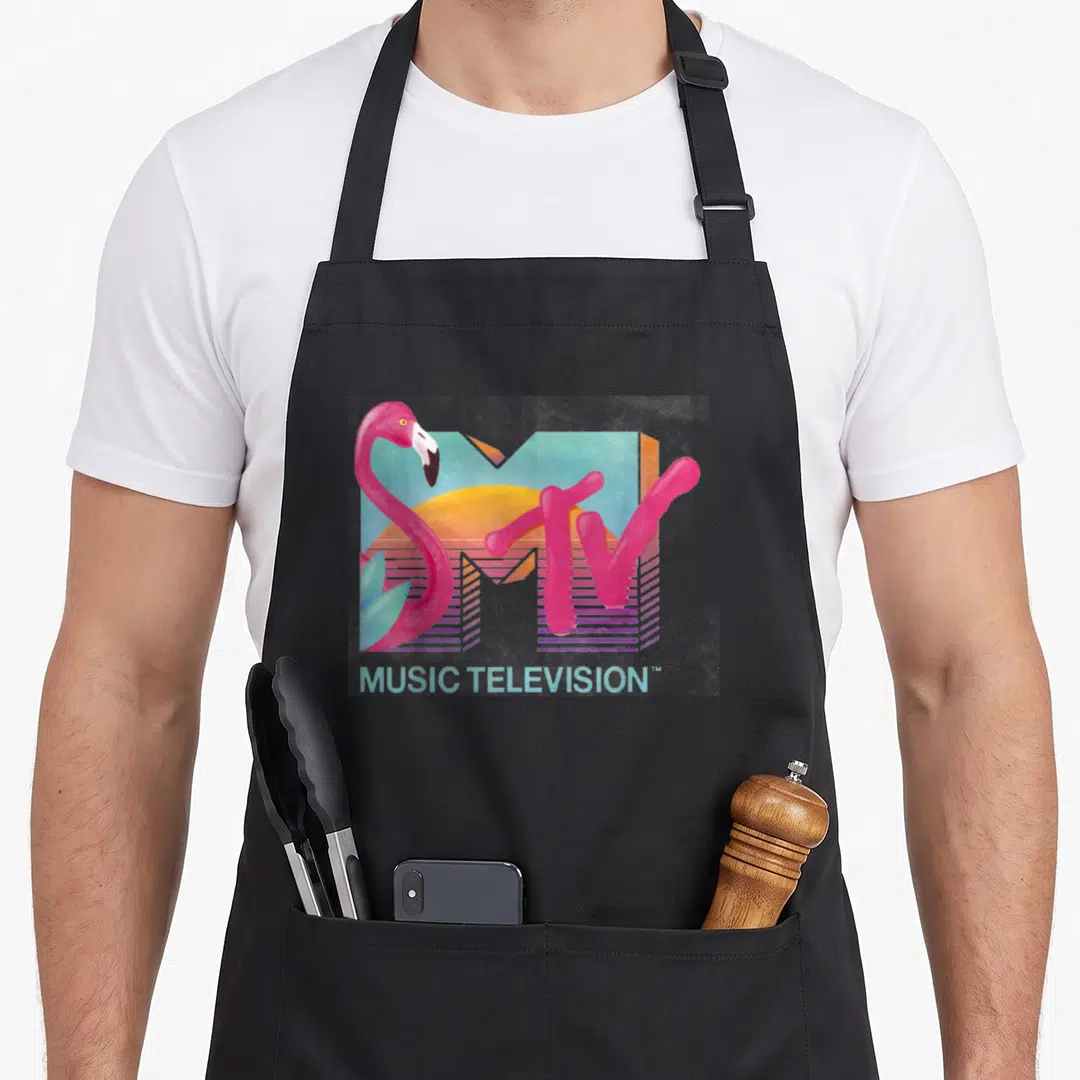 Distressed flamingo apron - Retro MTV logo with pink flamingo, sun, and MUSIC TELEVISION text in pastel colors — shown on a black cotton canvas apron against a white background
