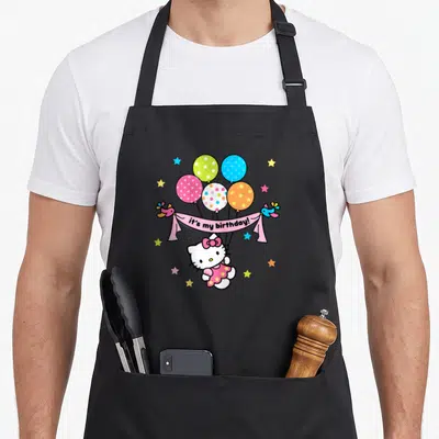 Vintage age birthday apron - Hello Kitty holding pink banner with five balloons and stars — shown on a black cotton canvas apron against a white background