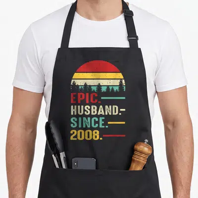 18th anniversary wedding apron - Retro sunset stripes and stacked text EPIC HUSBAND SINCE 2008 in red yellow beige teal — shown on a black cotton canvas apron against a white background