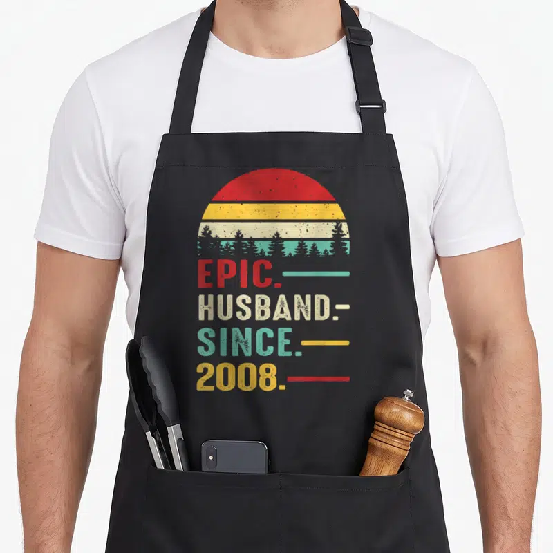 18th anniversary wedding apron - Retro sunset stripes and stacked text EPIC HUSBAND SINCE 2008 in red yellow beige teal — shown on a black cotton canvas apron against a white background