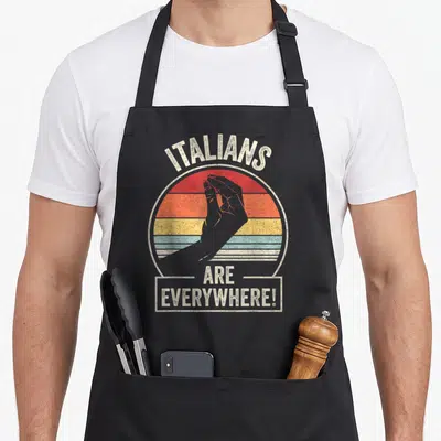 Catch italian apron - Retro hand gesture inside red orange yellow blue striped circle with text — shown on a black cotton canvas apron against a white background