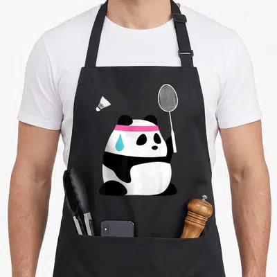 Exhausted animal apron - Cartoon panda with pink headband holding badminton racket, blue sweat drop, shuttlecock nearby — shown on a black cotton canvas apron against a white background