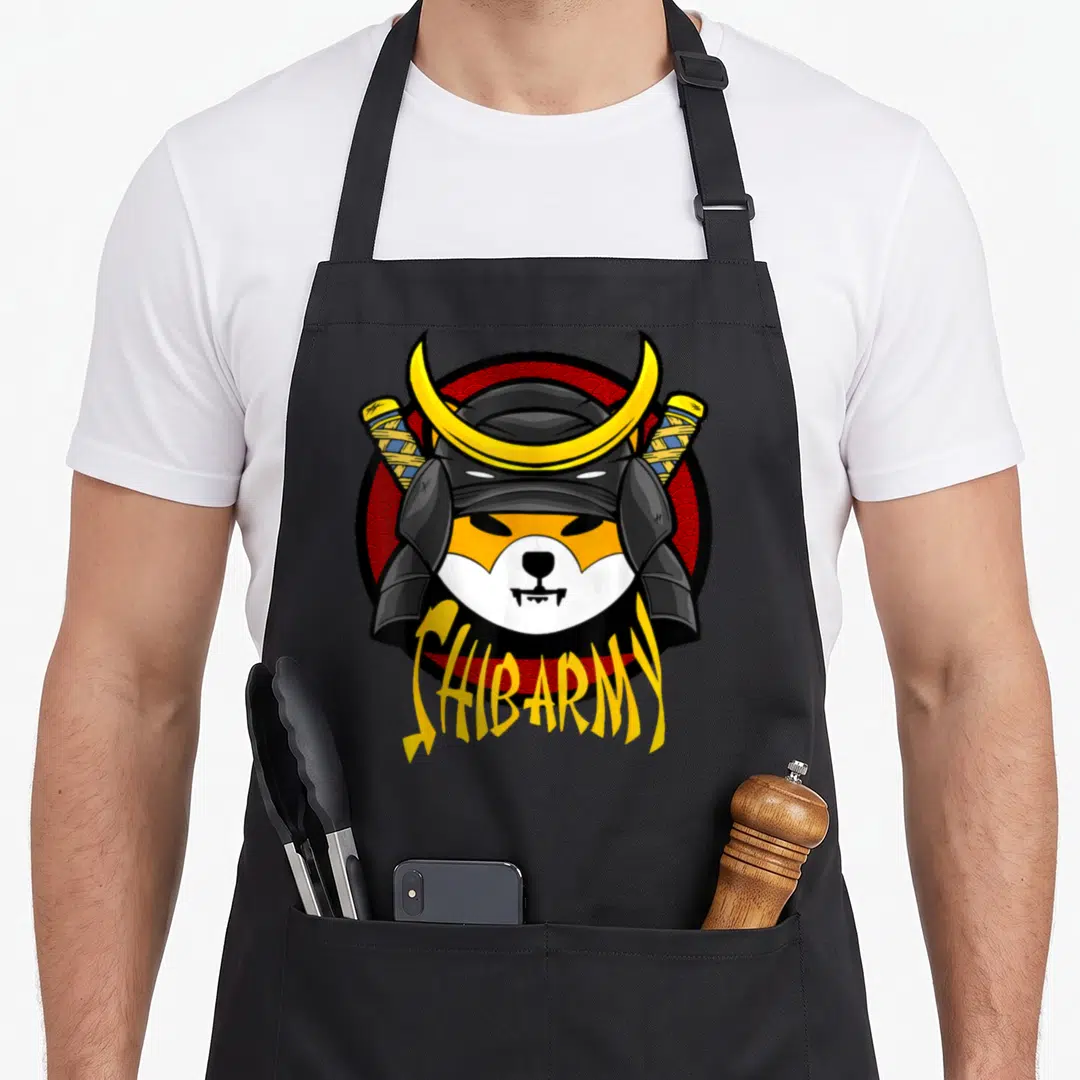 Shib coin apron - Cartoon dog head in samurai helmet with crossed swords and SHIBARMY text on red circle — shown on a black cotton canvas apron against a white background