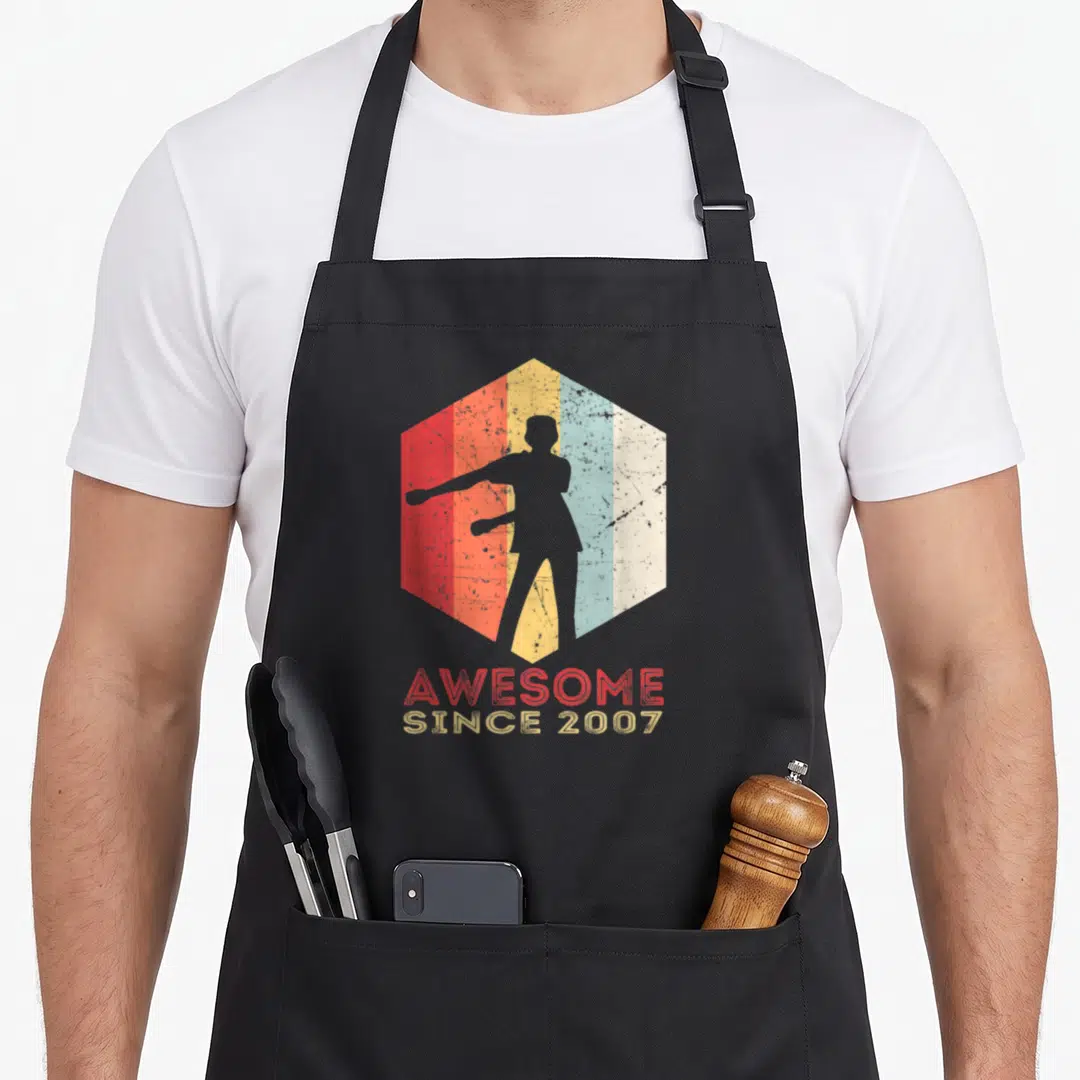 Floss trendy apron - Retro hexagon with striped background, grey flossing silhouette, and AWESOME SINCE 2007 text — shown on a black cotton canvas apron against a white background