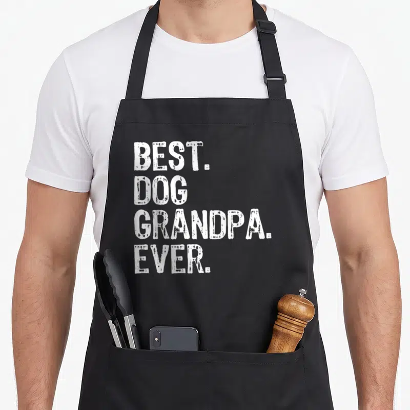 Dog grandpa apron - White stacked text reading best dog grandpa ever on grey background — shown on a black cotton canvas apron against a white background