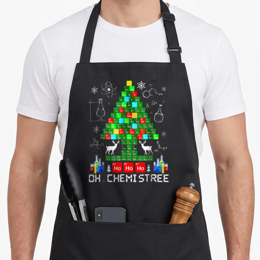 Chemistree christmas tree apron - Periodic table Christmas tree with OH CHEMISTREE text, flasks, reindeer — shown on a black cotton canvas apron against a white background