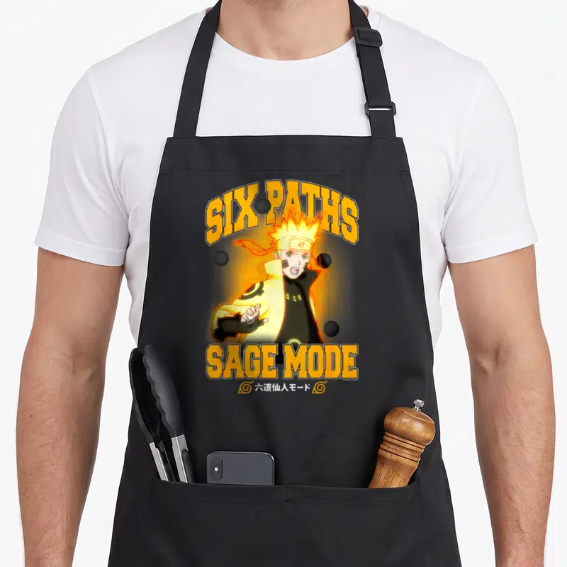Six sage apron - Naruto Six Paths Sage Mode with four black spheres and orange text on black — shown on a black cotton canvas apron against a white background