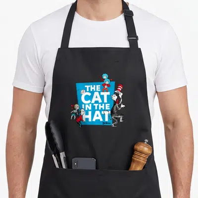 Cat character aprons - Stacked white text THE CAT IN THE HAT on blue square with cartoon cat children and Things — shown on a black cotton canvas apron against a white background