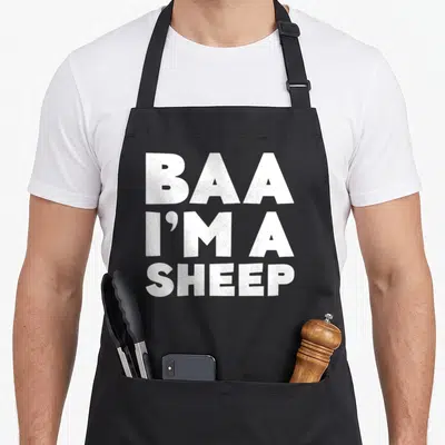 Baa sheep apron - White stacked text reading BAA I'M A SHEEP on grey background — shown on a black cotton canvas apron against a white background