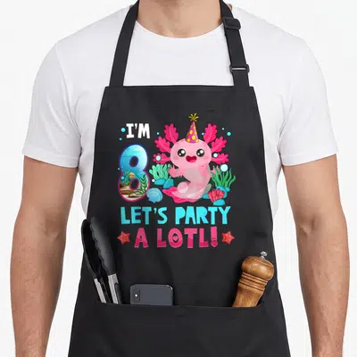 Lotl axolotl birthday apron - Pink axolotl wearing party hat with I'M 8 LET'S PARTY A LOTL text and underwater coral — shown on a black cotton canvas apron against a white background