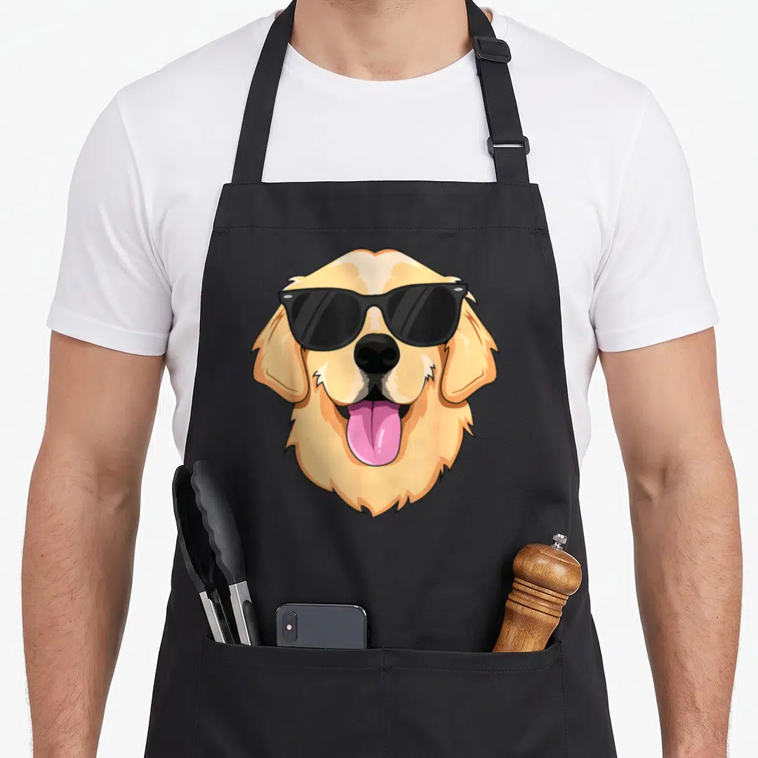Sunglass golden retriever apron - Cartoon golden dog head wearing black sunglasses with pink tongue sticking out — shown on a black cotton canvas apron against a white background
