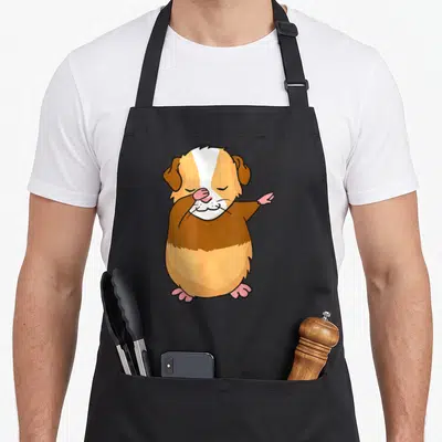 Dabbing guinea pigs apron - Cartoon guinea pig dabbing in brown, white, tan, and pink colors — shown on a black cotton canvas apron against a white background