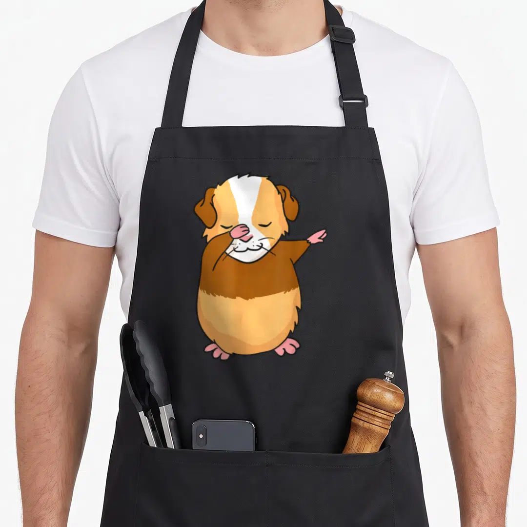 Dabbing guinea pigs apron - Cartoon guinea pig dabbing in brown, white, tan, and pink colors — shown on a black cotton canvas apron against a white background