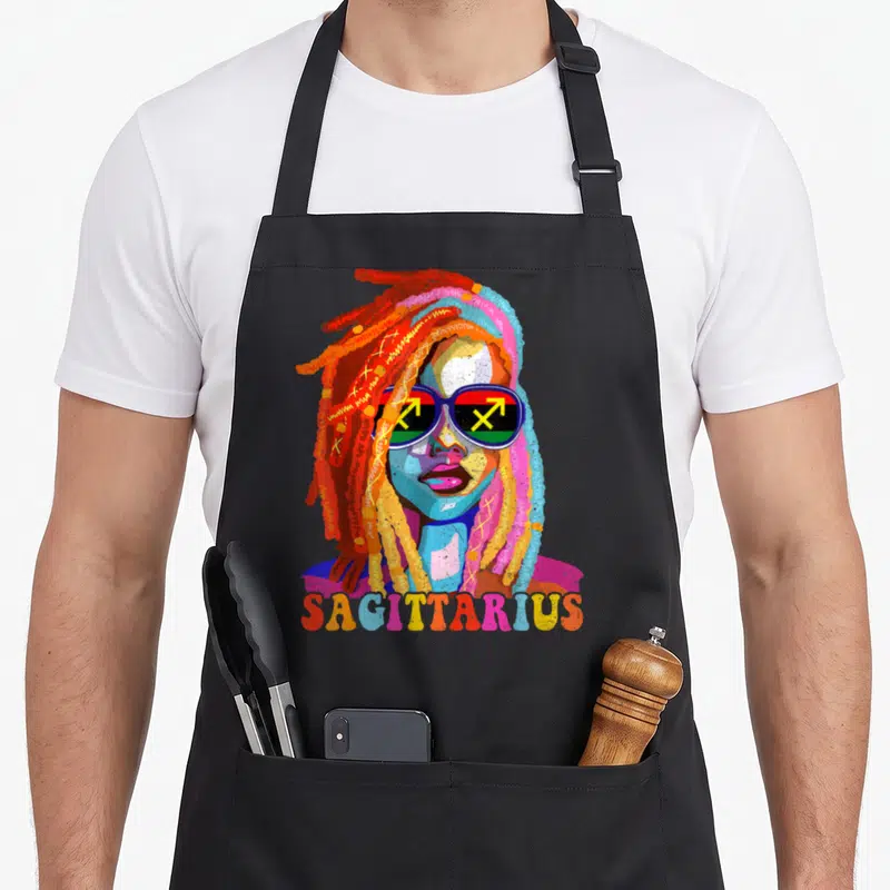 Sagittarius african american aprons - Colorful cartoon woman with dreadlocks, sunglasses showing Sagittarius arrows — shown on a black cotton canvas apron against a white background