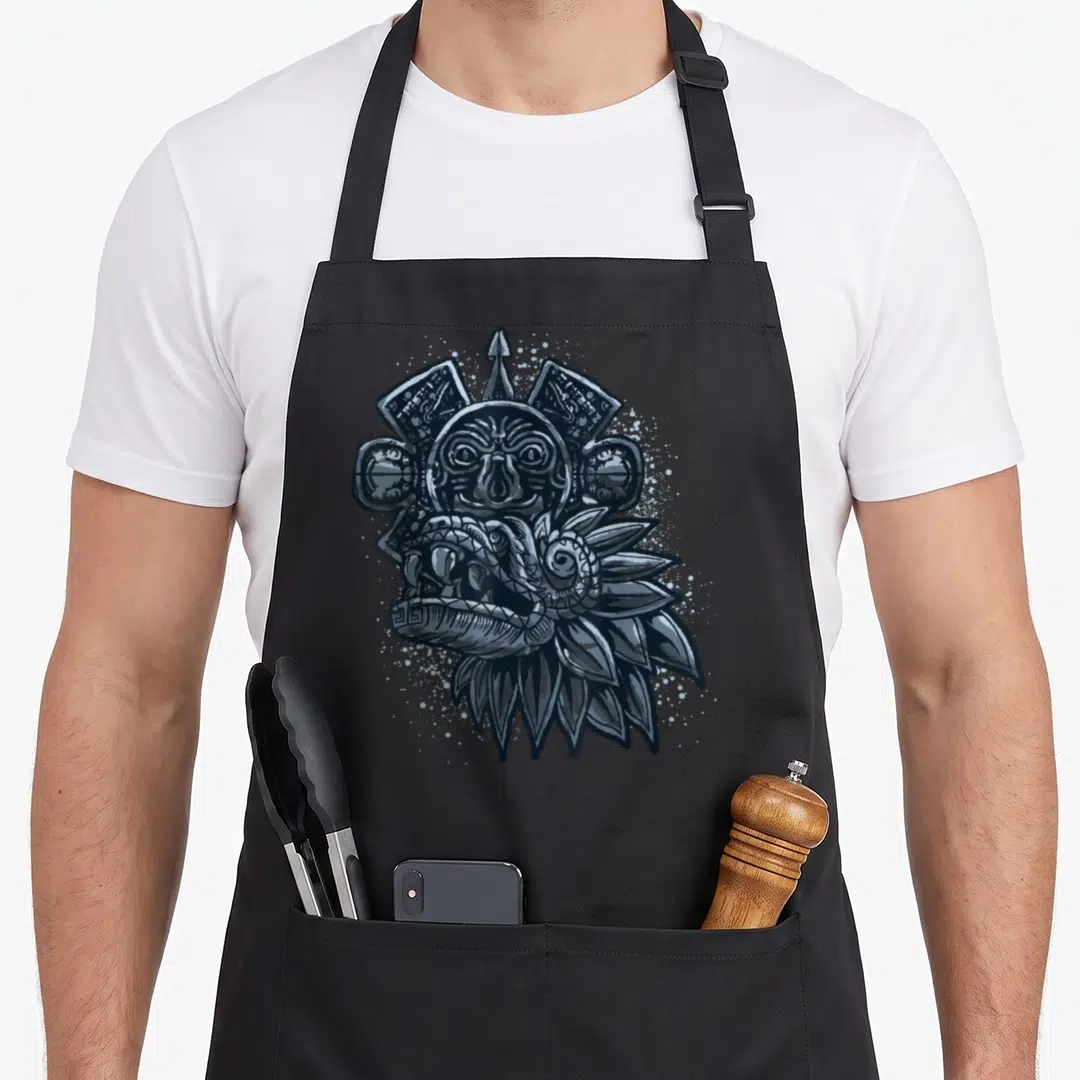 Aztec dragon apron - Grey line art Aztec deity mask with coiled serpent head and geometric background elements — shown on a black cotton canvas apron against a white background