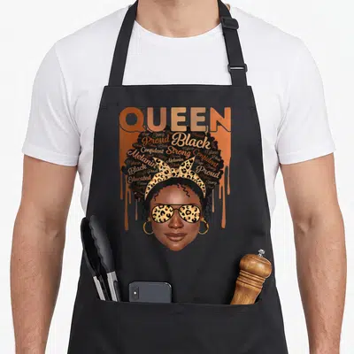 Educated strong african american aprons - Woman with afro filled with Black Melanin Strong Proud words, leopard — shown on a black cotton canvas apron against a white background
